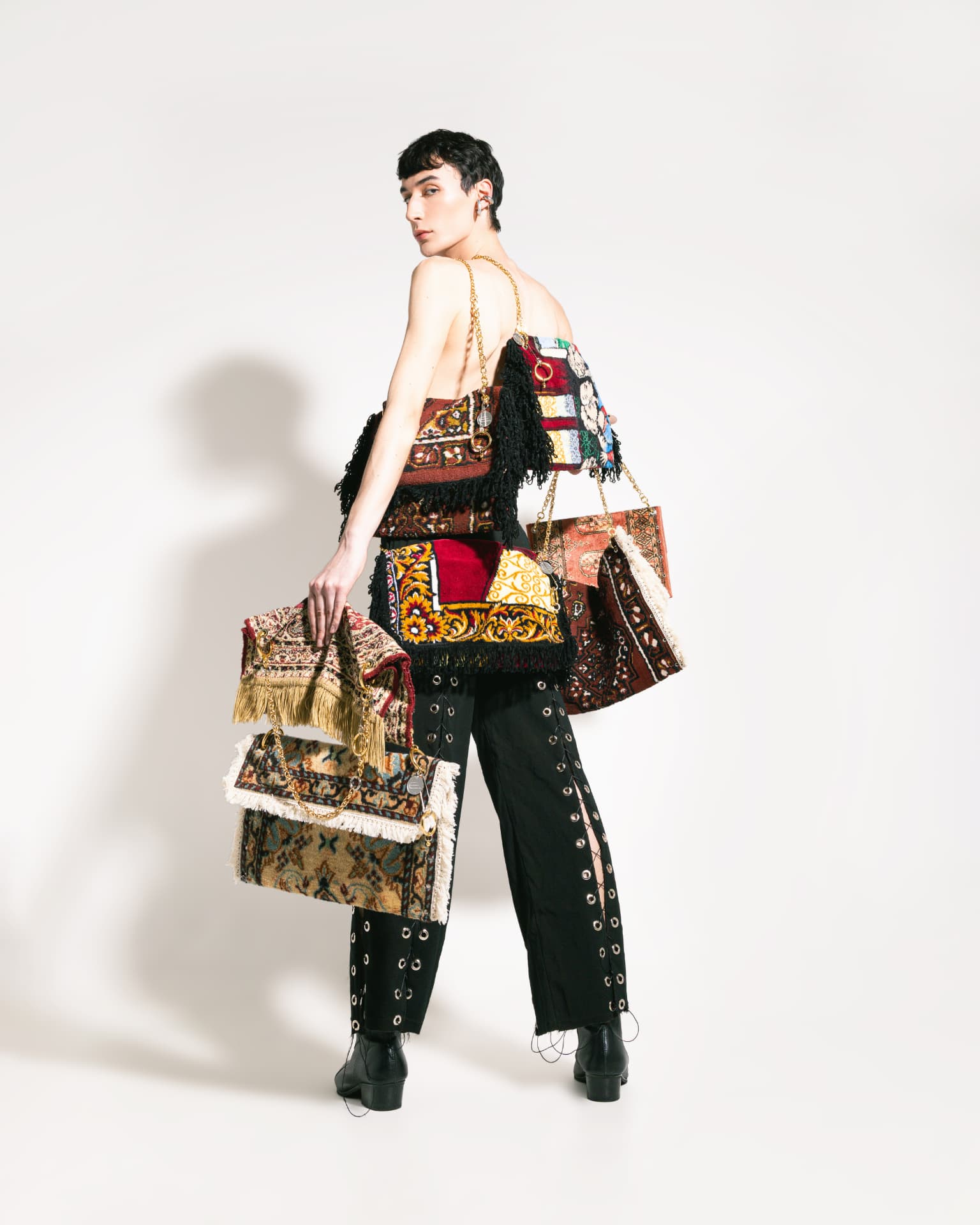 Campanha TAPISS S01 — modelo com várias bolsas TAPISS no estúdio